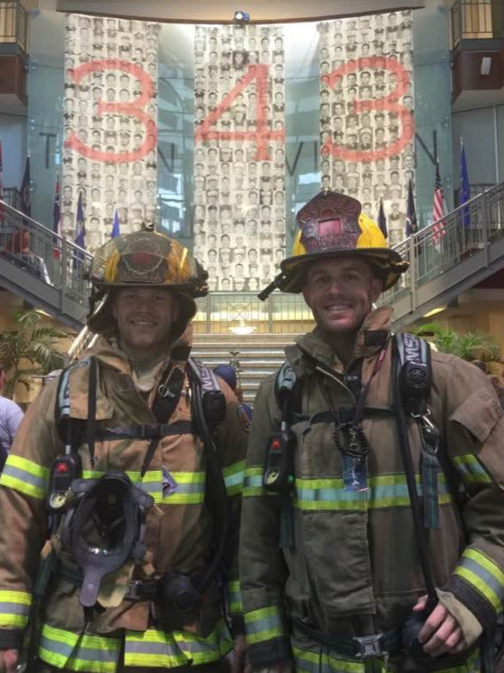 Two firefighters at a memorial honoring the 343 firefighters lost on September 11